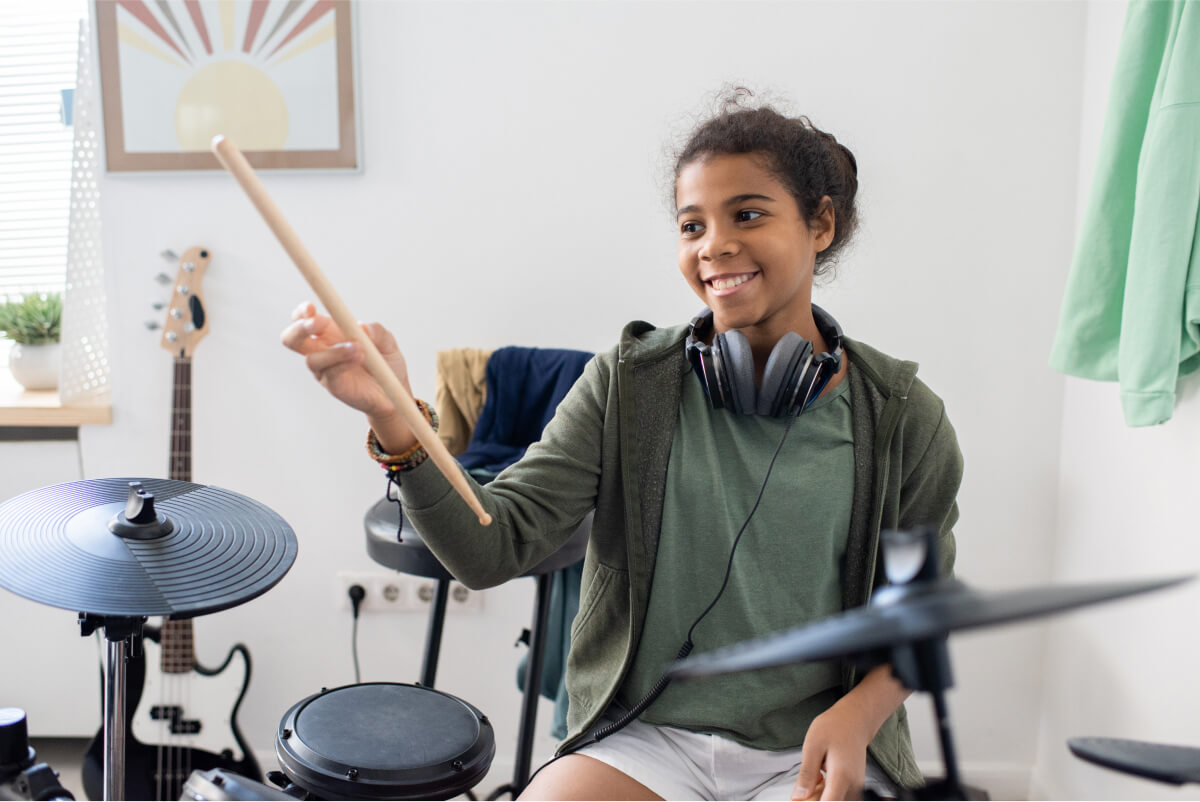happy-cute-schoolgirl-with-drumsticks-hitting-drum-2021-12-16-00-28-52-utc.jpg