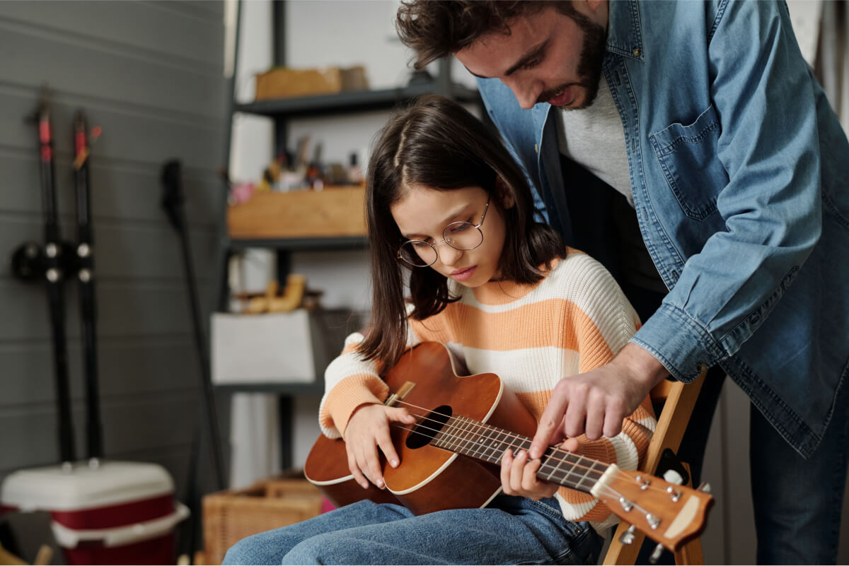 little-girl-in-eyeglasses-learning-to-play-guitar-2022-04-29-00-27-38-utc.jpg